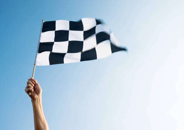 istock Man hand holding checkered flag in the wind 811755332