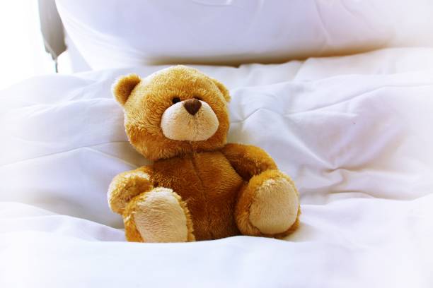 istock Lonely bear is in bed on white pillow 811773150