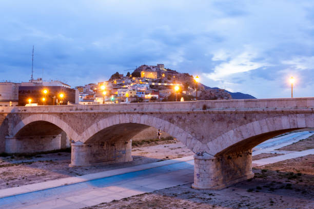Historic stone bridge in Lorca, Spain Historic stone bridge over the Guadalentin river in Lorca, illuminated at night. Province of Murcia, southern Spain lorca stock pictures, royalty-free photos & images