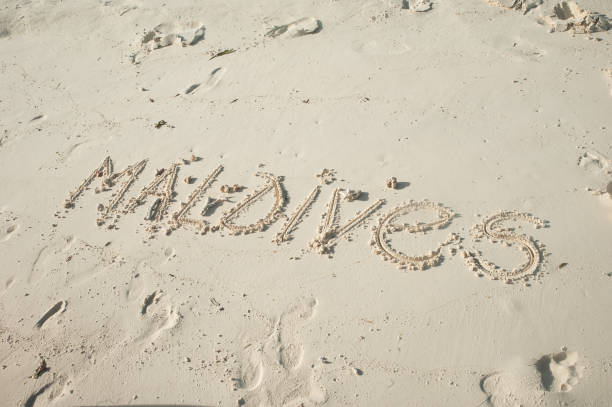 istock Inscription Maldives on white sand. Maldives 811798390