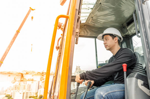 istock Asian man operator driving backhoe on construction zone. To destroy the old building 811827692