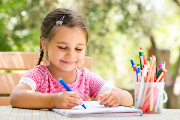 istock Little Girl Drawing Picture Outdoors In Summer 811832976