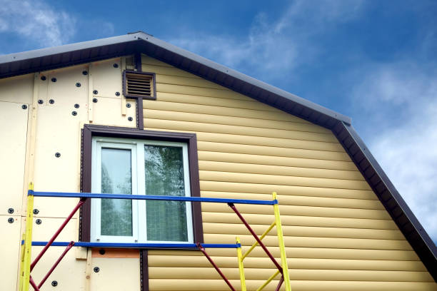 Siding panels mounting over insulation on building wall in sunny day