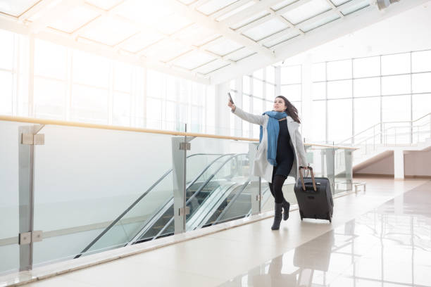 Young business woman with suitcase running to catch the plane stock photo