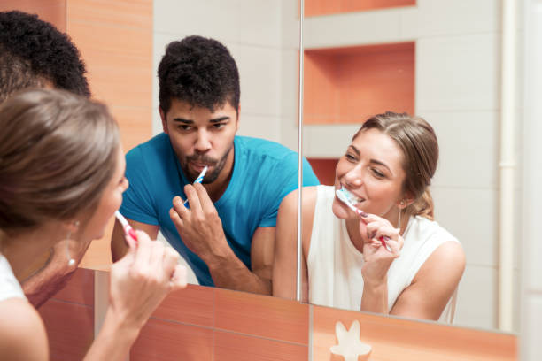 istock Young happy couple brushing teeth in the bathroom 811845204