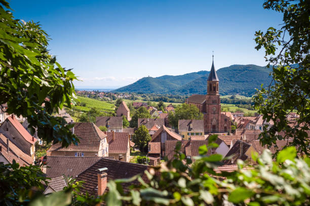 typisch franse dorpje met kerk, daken en heuvels op de achtergrond - landschap dorp stockfoto's en -beelden
