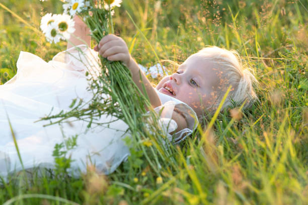 istock little girl outdoors lying in the grass summertime 811897098