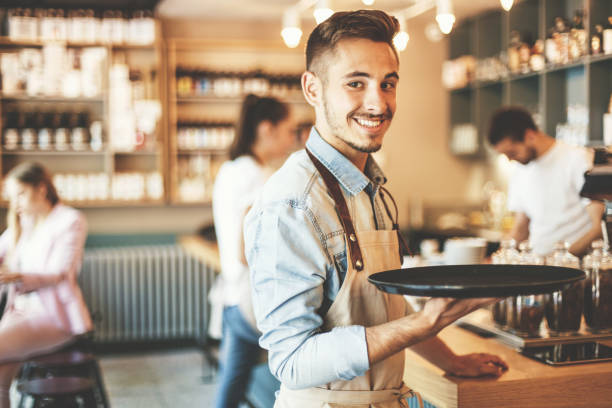 Young waiter serving Confident young waiter. waiter stock pictures, royalty-free photos & images