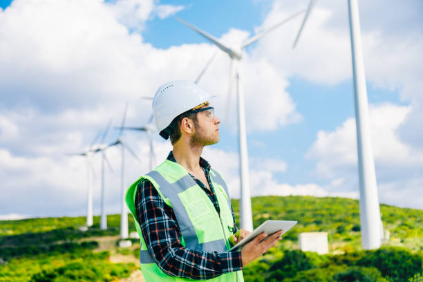 istock Young engineer looking and checking wind turbines at field 811924300