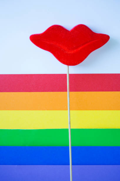 Red lips on wooden stick and rainbow flag.