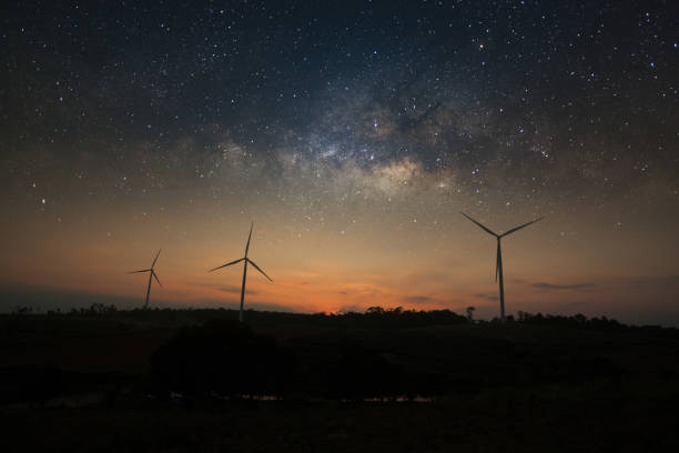 istock Milky way galaxy over wind turbine clean energy 811944690