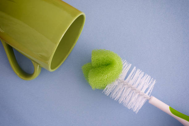 Bottle brush and green mug. Blue background.