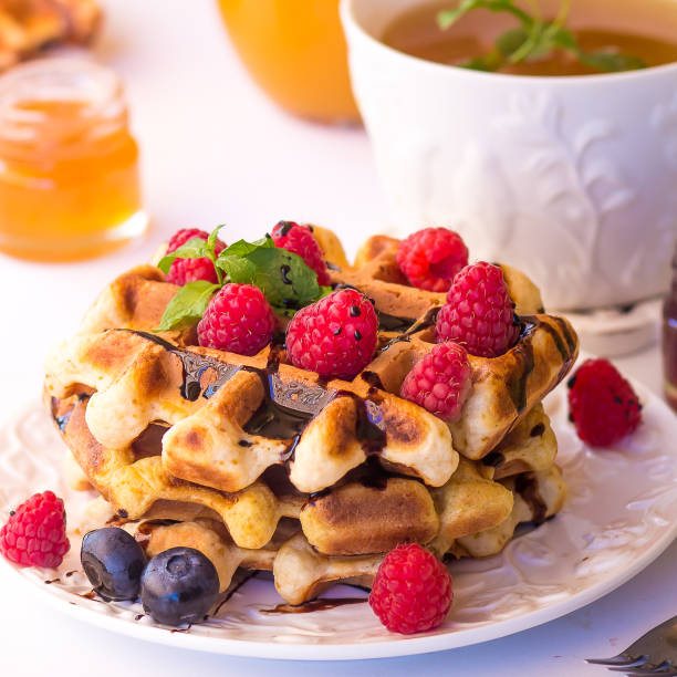 istock Belgium waffles with raspberries, chocolate and syrup on a plate. 811952010