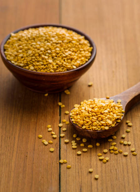 toor dal or arhar dal or raw pulses toor dal or arhar dal or raw pulses in wooden spoon and bowl singh stock pictures, royalty-free photos & images