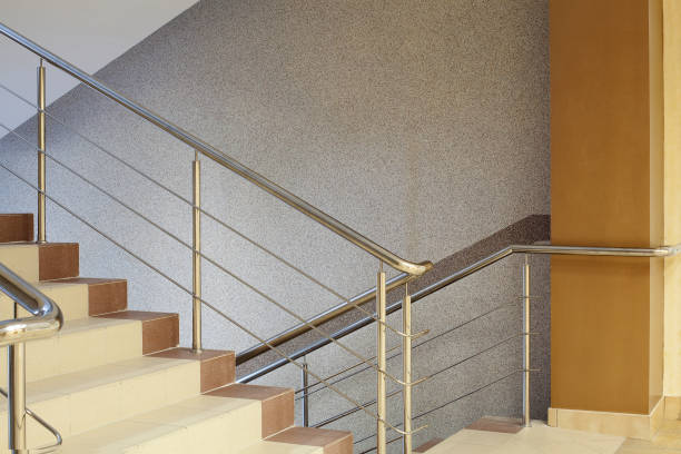 istock Brown staircase with metal railing, gray wall 811960954
