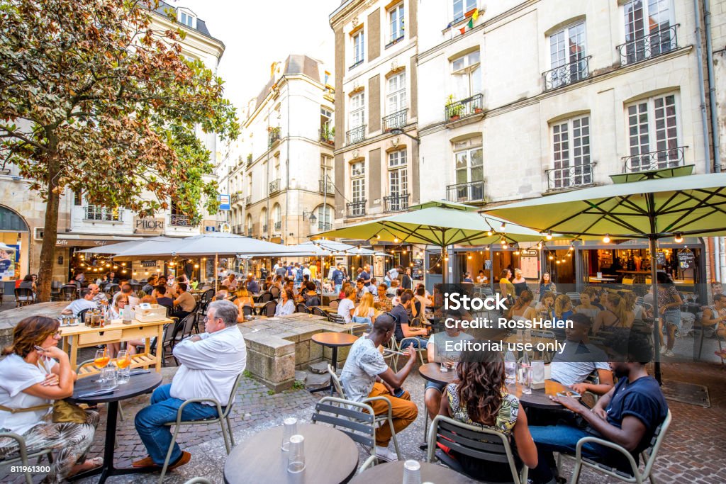 Nantes city in France NANTES, FRANCE - May 27, 2017: Street view with cafes and restaurant full of people in the old town of Nantes city in France Nantes Stock Photo