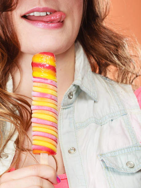 istock woman in summer hat eating ice pop cream 811964270