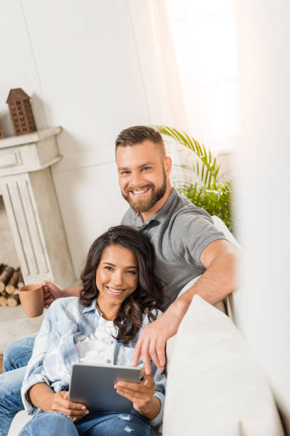 istock young smiling couple relaxing and using digital tablet at home 811967210