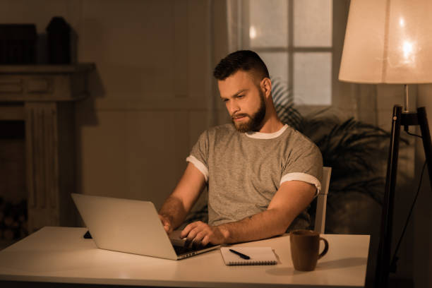 istock young pensive man working on laptop while sitting at home 811967572