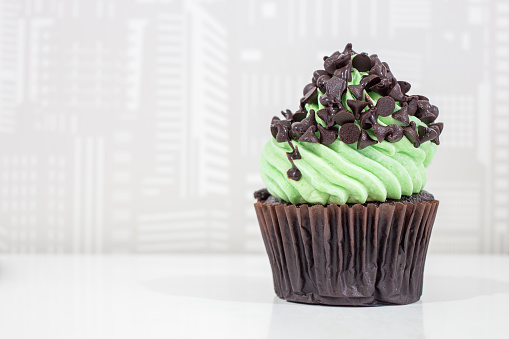 Green cupcakes with cream on top and Chocolate chip placed on the table