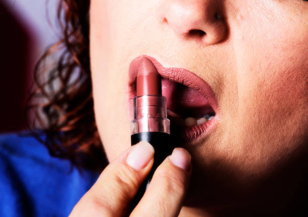 Woman applies lipstick to her lips
