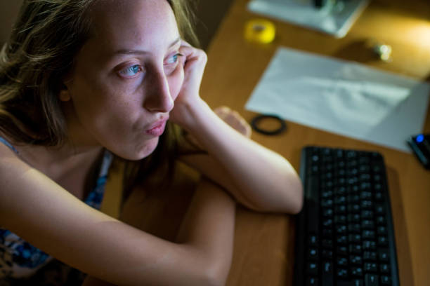 istock Pensive and tired young woman looking at computer 812009742