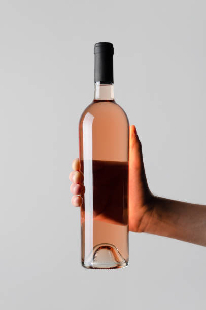 istock Wine Bottle Mock-Up - Male hands holding a wine bottle on a gray background 812017410
