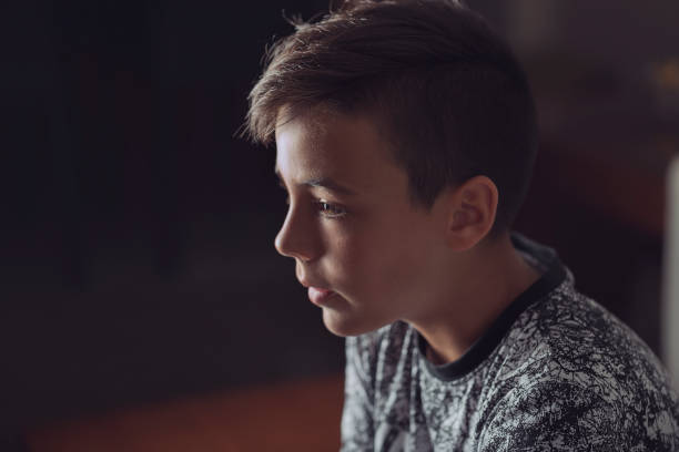 istock Boy with green eyes looking at the television 812034800