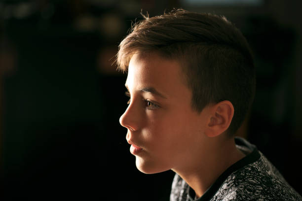 istock Boy with green eyes looking at the television 812034810