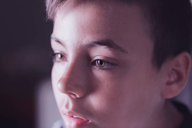 istock Boy with green eyes looking at the television 812034818