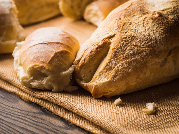 istock Freshly baked bread on burlap dark wooden background 812037802