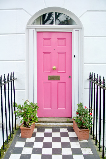 A large brown wooden door on a modern white church building.