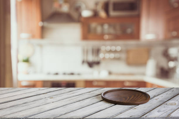 istock Blurred kitchen background. Empty wooden tabletop and defocused modern kitchen for display or montage your products. 812050034