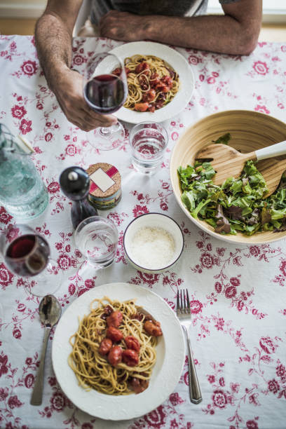 istock Spaghetti meal, arugula salad and red wine on a table 812052296