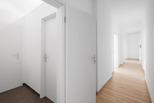 new empty corridor, white walls and doors and wooden floor real estate interior - new empty corridor, white walls and doors and wooden floor bathroom geyser stock pictures, royalty-free photos & images