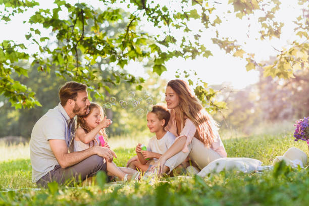 istock Playful family blowing bubbles and laughing togther 812064310