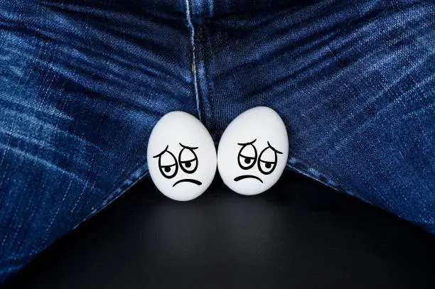 sad faces on the testicles of the guy. White eggs - a symbol of man's balls with the comic cartoon faces
