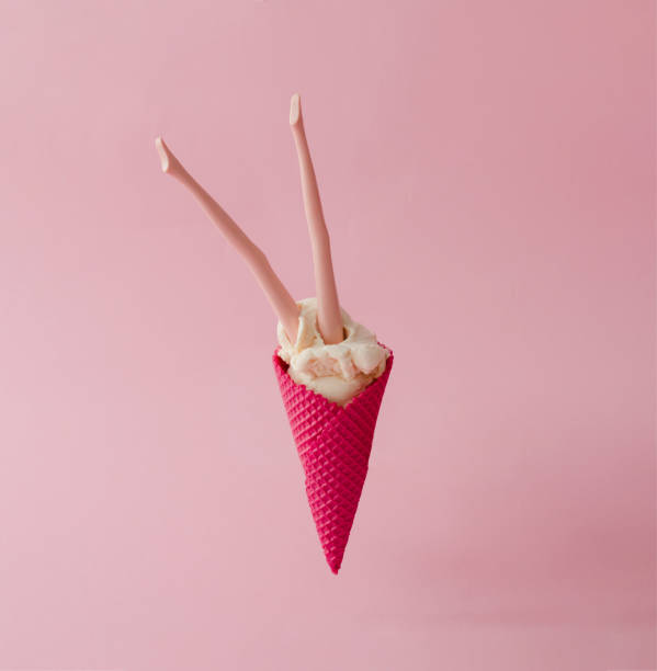 istock Doll legs in vanilla ice cream with red cone on pink pastel background. Creative summer concept. 812085678
