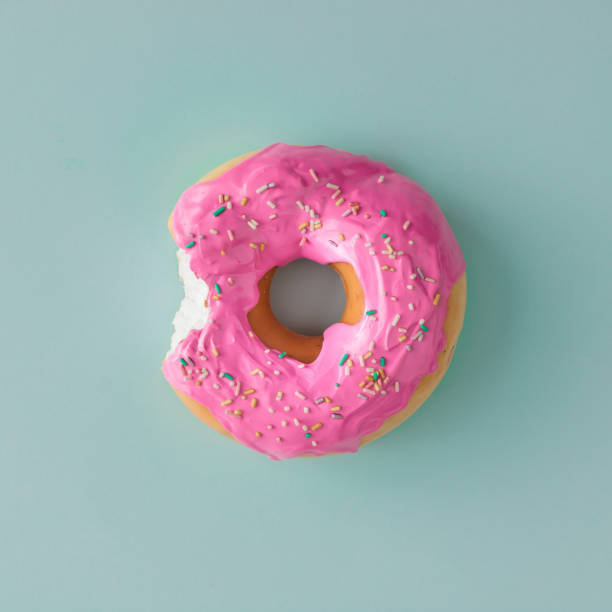 istock Pink glazed donut on blue pastel background. Flat lay. Creative concept. 812085726