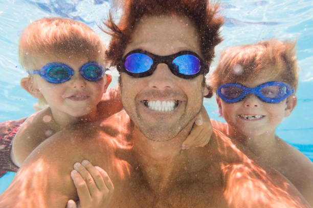 istock Dad And Kids Having Fun Underwater In A Pool 812090742