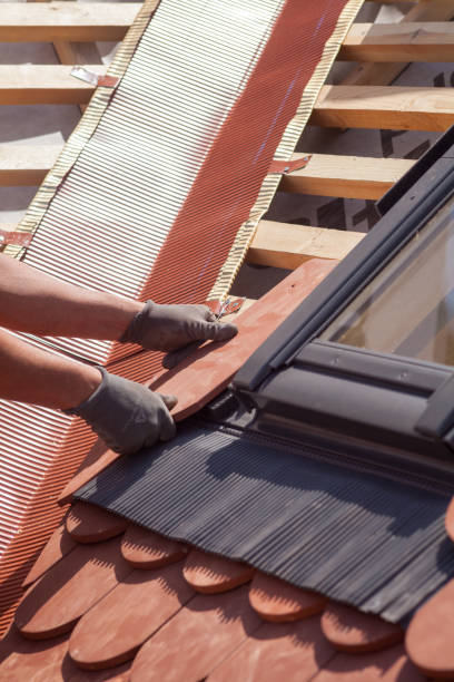 istock Hands of roofer laying tile on the roof. Installing natural red tile. 812095676