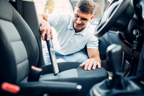 istock Man cleans car interior with vacuum cleaner 812101976