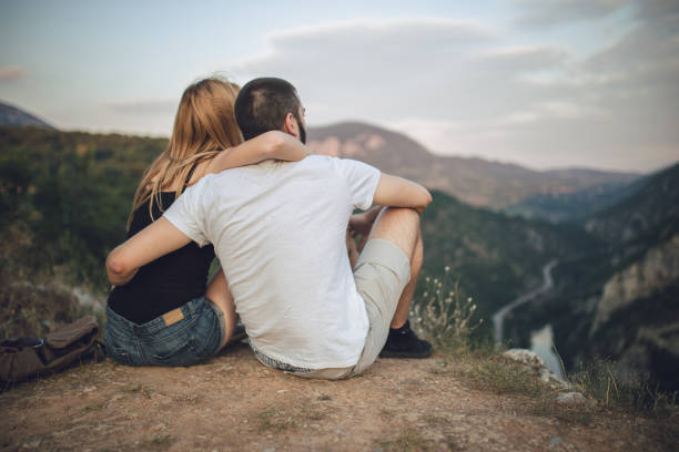 istock Young couple sitting on the cliff 812146022