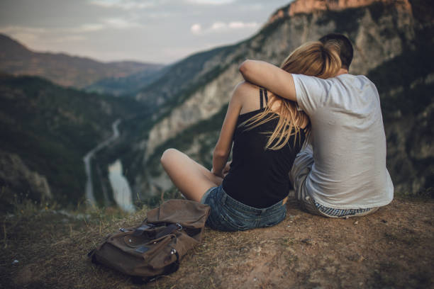 istock Young couple sitting on mountain top 812146046
