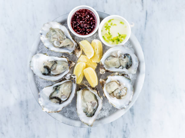 istock Fresh oysters platter with sauce and lemon 812163882