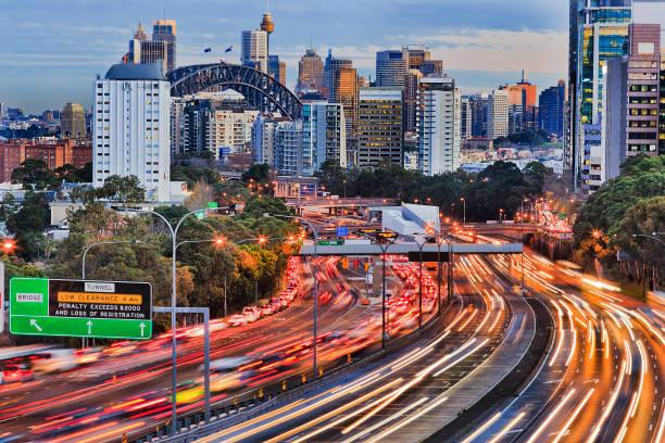 Warring Set N Syd 105mm Long exposure blurred vehicle motion on multi-lane Warringah freeway going through North Sydney in Sydney, Australia. Headlights and backlights during rush hour commute towards Sydney harbour bridge and CBD towers. sydney harbour bridge stock pictures, royalty-free photos & images