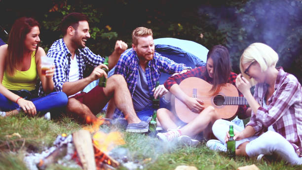 istock Five friends sitting next to campfire and singing song 812214168