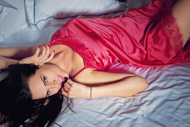 Beautiful woman in playful behaviour is smiling in the bed Beautiful woman in playful behaviour is smiling in the bed seduction stock pictures, royalty-free photos & images