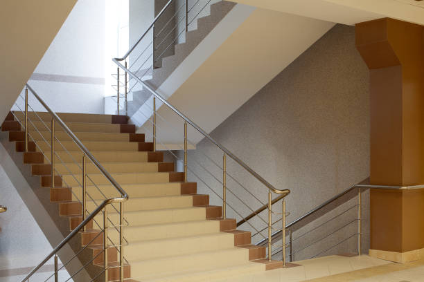 istock Brown staircase with metal railing, gray wall 812237290