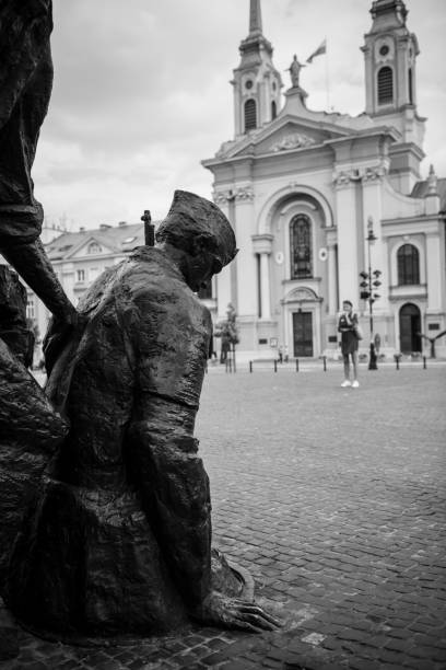 A woman standing in Warsaw's Krasiski Square looks toward the Warsaw Uprising Monument, dedicated to the Warsaw Uprising of 1944. Sculpted by Wincenty Kuma, it was unveiled in 1989. (August 2016)